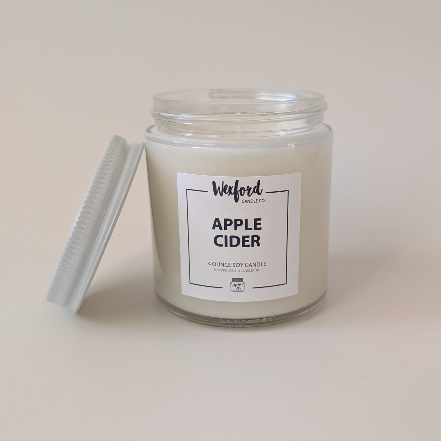 A 4-ounce soy candle in a clear glass jar with a white wax fill and a white label reading 'Waford Candle Co. APPLE CIDER'.