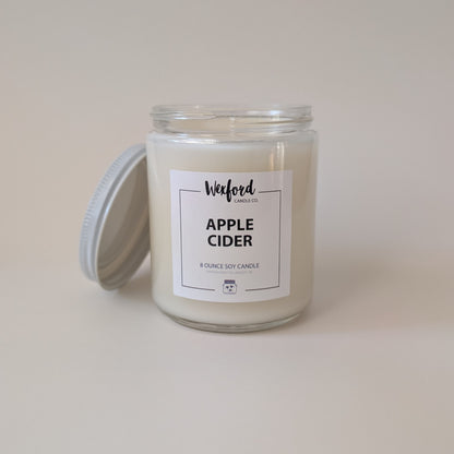 An 8 ounce soy candle in a clear glass jar with a white wax fill and a white label reading 'Wexford Candle Co. APPLE CIDER'.
