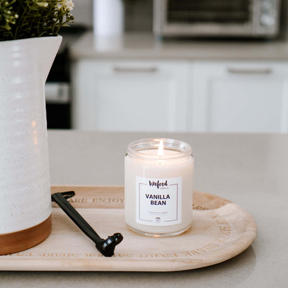 Vanilla bean candle on a wooden tray in a kitchen setting